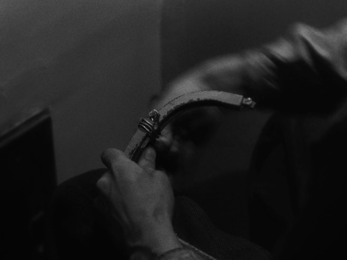 The main character builds a hook from his blanket and the metal wire from his bed